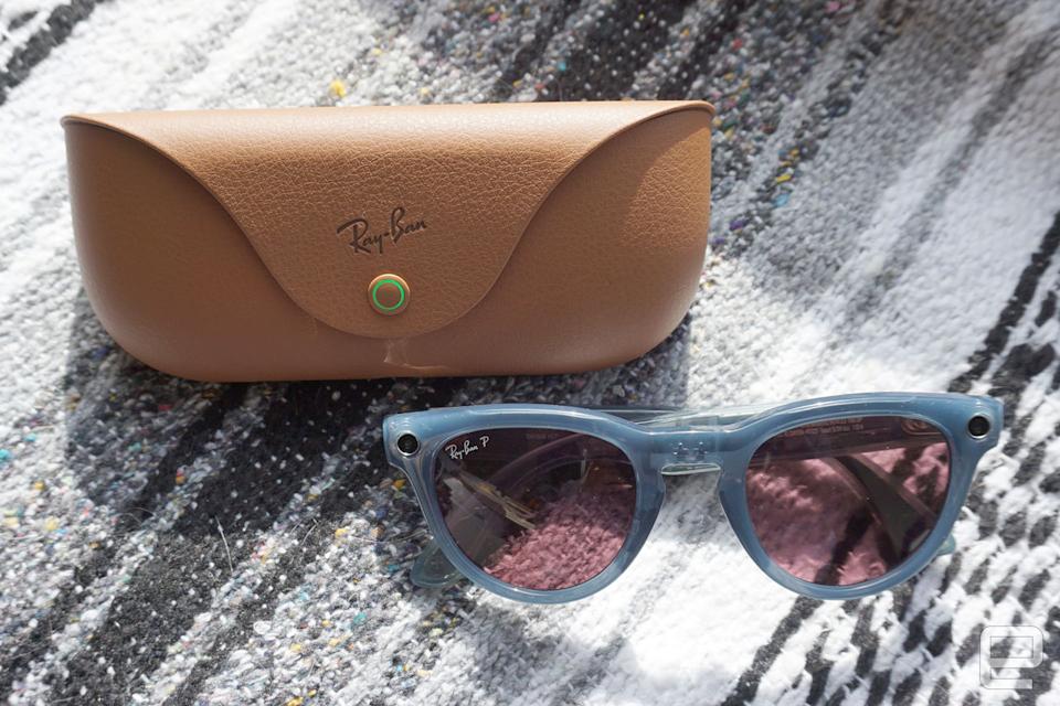 Smart sunglasses sitting on a blanket next to a case.