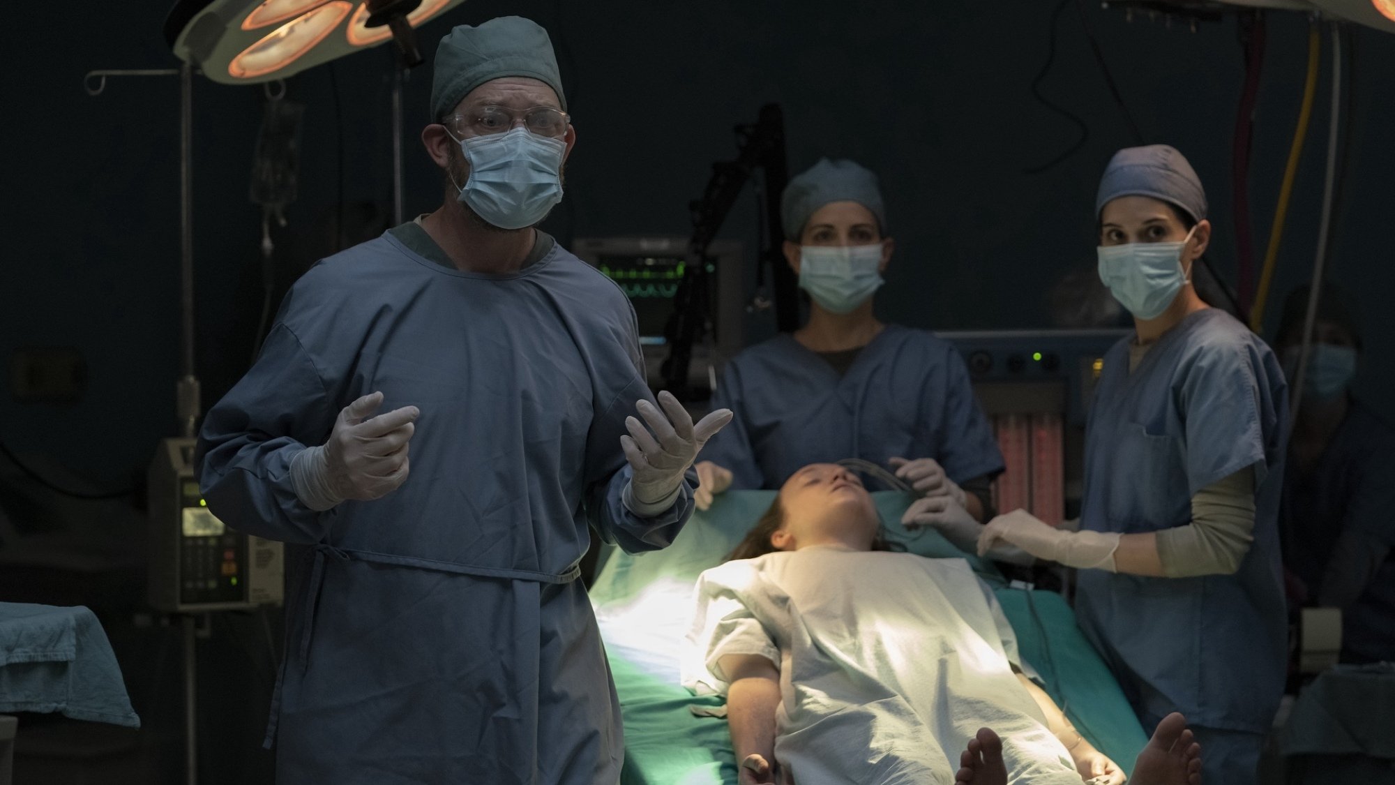 A team of doctors surround an unconscious Ellie (Bella Ramsey) in